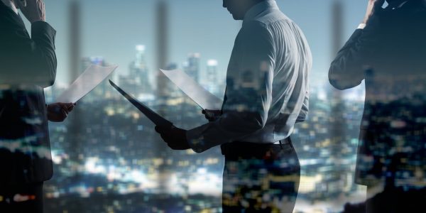 businessman with paper standing in night office